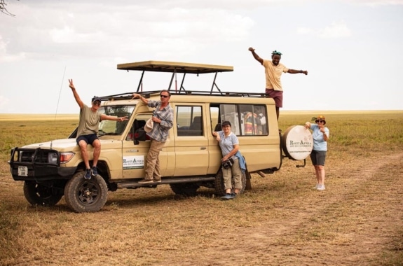 Das Team von Rocky Africa & Eco Experience mit dem Safari-Fahrzeug in der Serengeti